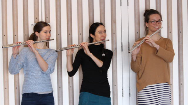 Three young women playing the flute