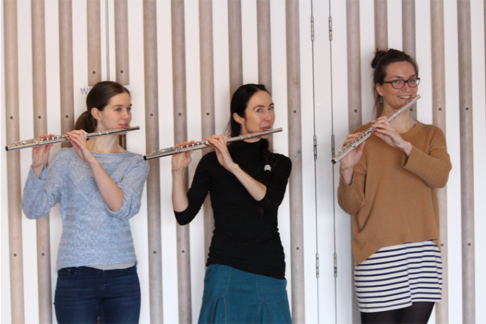 Three young women playing the flute