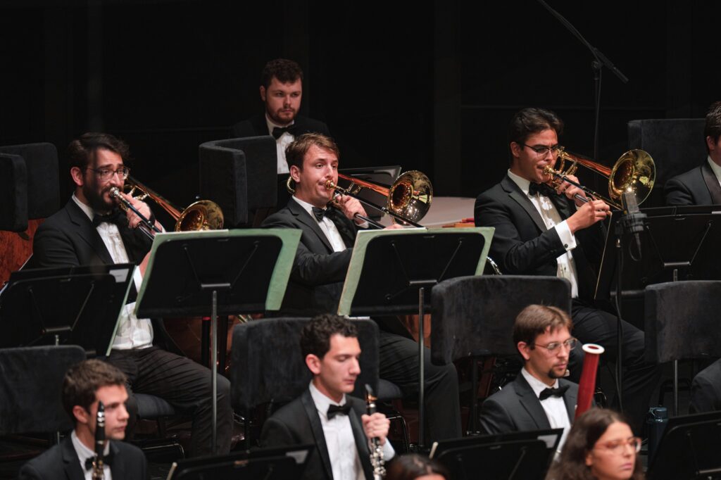 An orchestra of young musicians perform on stage.