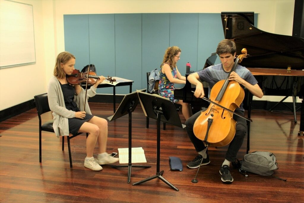 AYO Chamber Players - A piano trio rehearses in a classroom. 