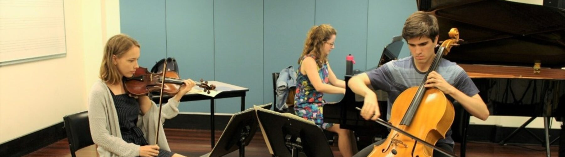 AYO Chamber Players - A piano trio rehearses in a classroom.