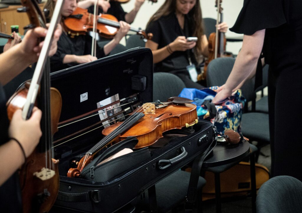 An instrument case lies open with a violin inside.