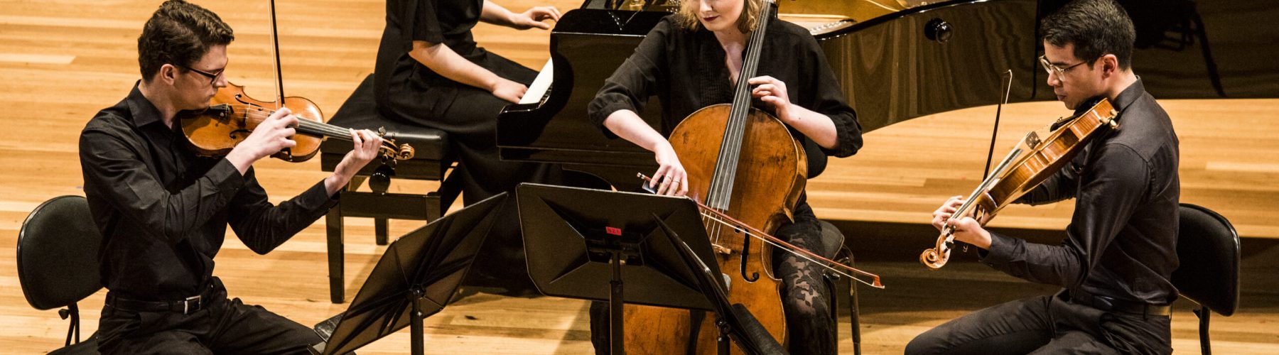 Four musicians playing together in a small ensembkle at AYO Chamber Players 2022. They are wearing concert black clothes.