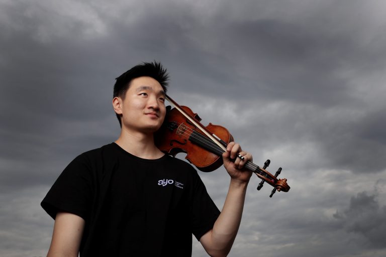 Young musician with his violin in the shoulder with a cloudy background