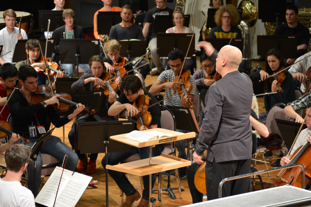 Fabian Russell conducts an orchestra during rehearsal.