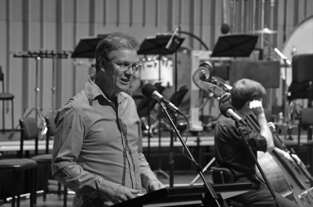 Conductor Guy Noble presents from a podium during AYO National Music Camp 2014.