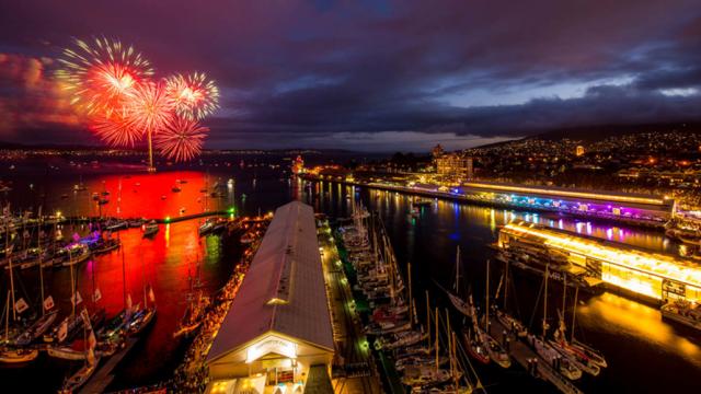 A view of Hobart at night with fireworks in the sky.