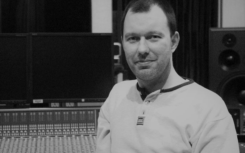 Greyscale portrait of audio engineer Jakub Gaudasinski in a recording studio.