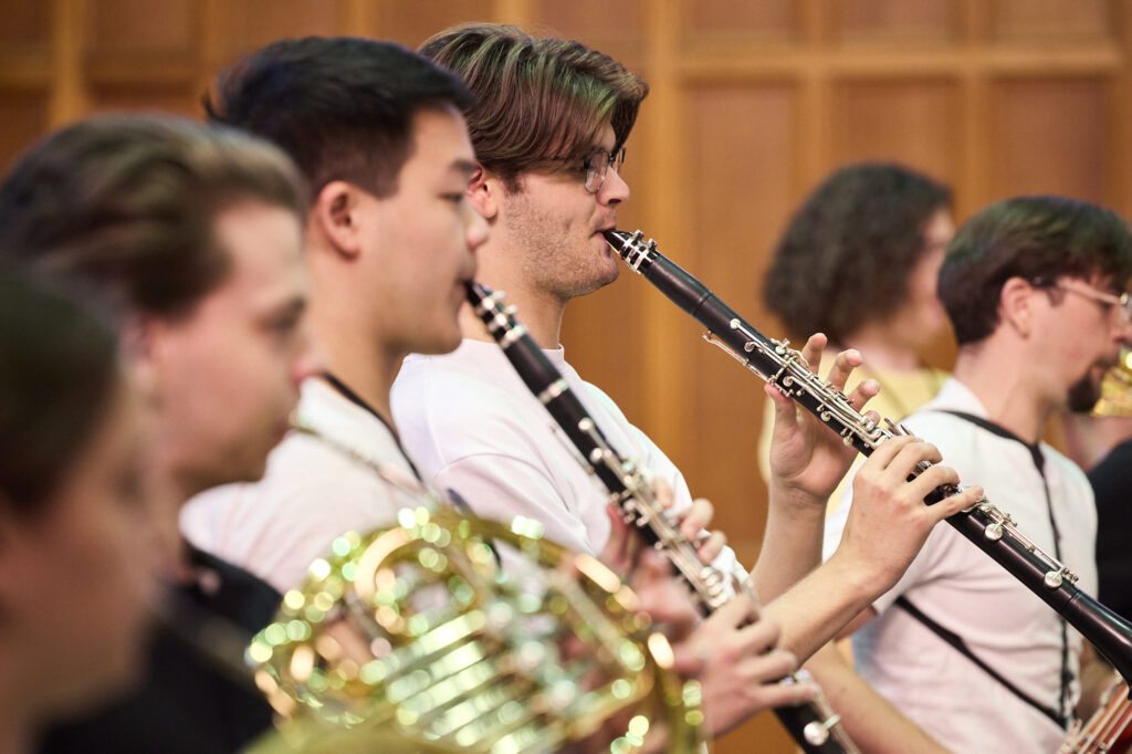 View of two clarinettists and a French Horn player rehearsing during AYO National Camp 2023.