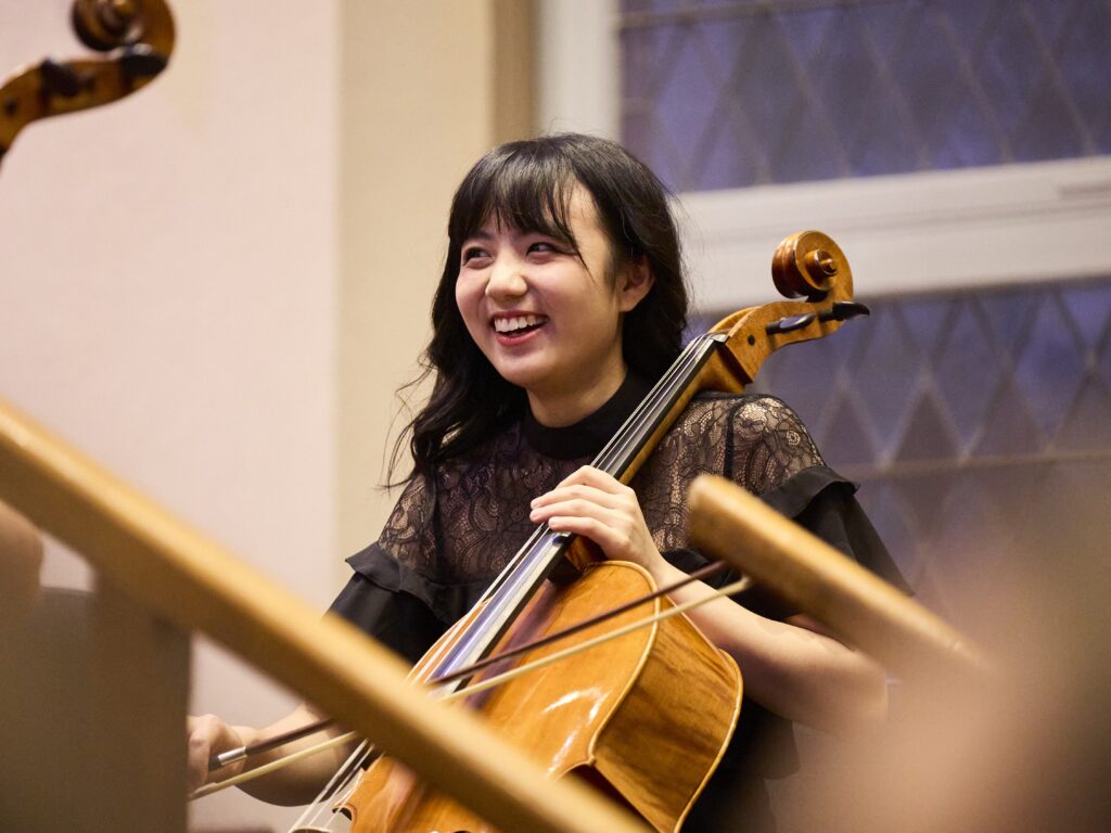 A young cellist smiles during a performance.