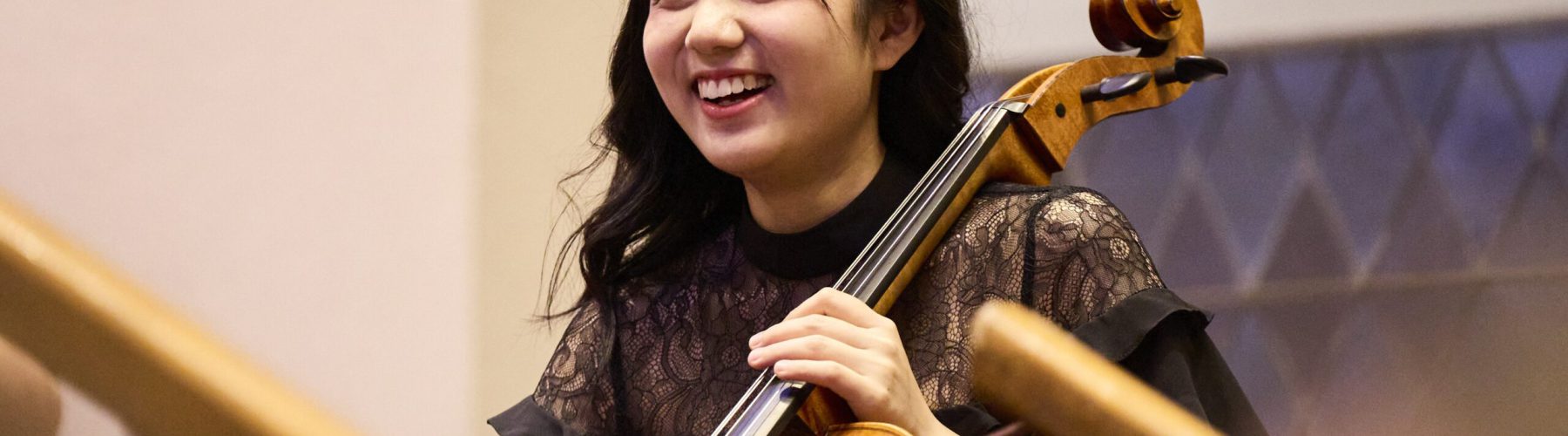 A young cellist smiles during a performance.