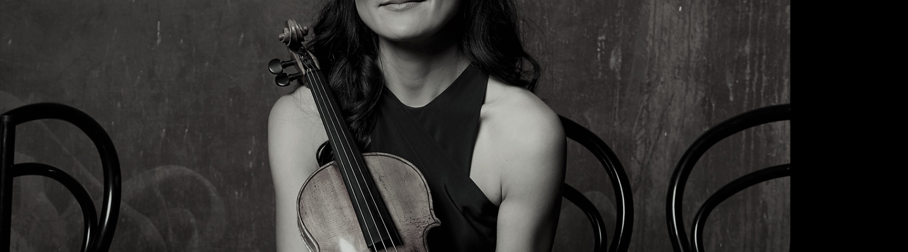 Greyscale portrait of ASO concertmaster Natsuko Yoshimoto holding her violin.