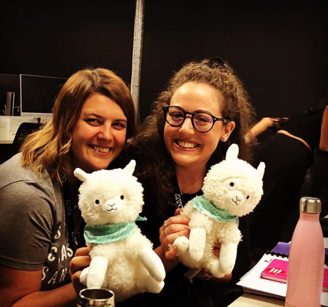 Orchestral Management participant Jordan Armstrong and tutor Angela Chilcott smile at the camera, posing with two fluffy toy alpacas.