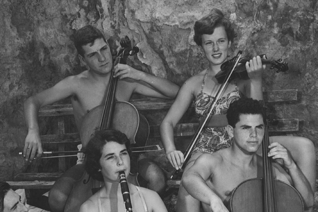 A black and white photo of AYO musicians in the 1950s. Peter Weiss plays the cello.
