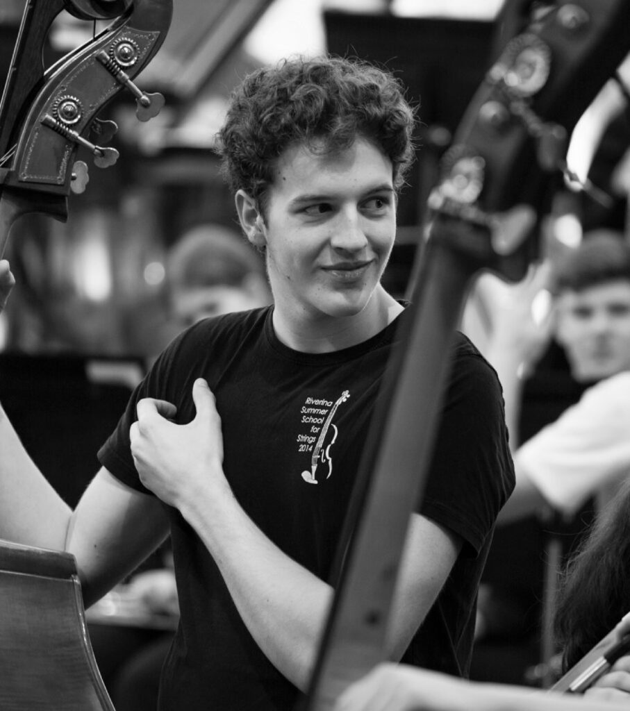 AYO double bassist Sebastian Pini pictured with his instrument during an orchestral rehearsal.