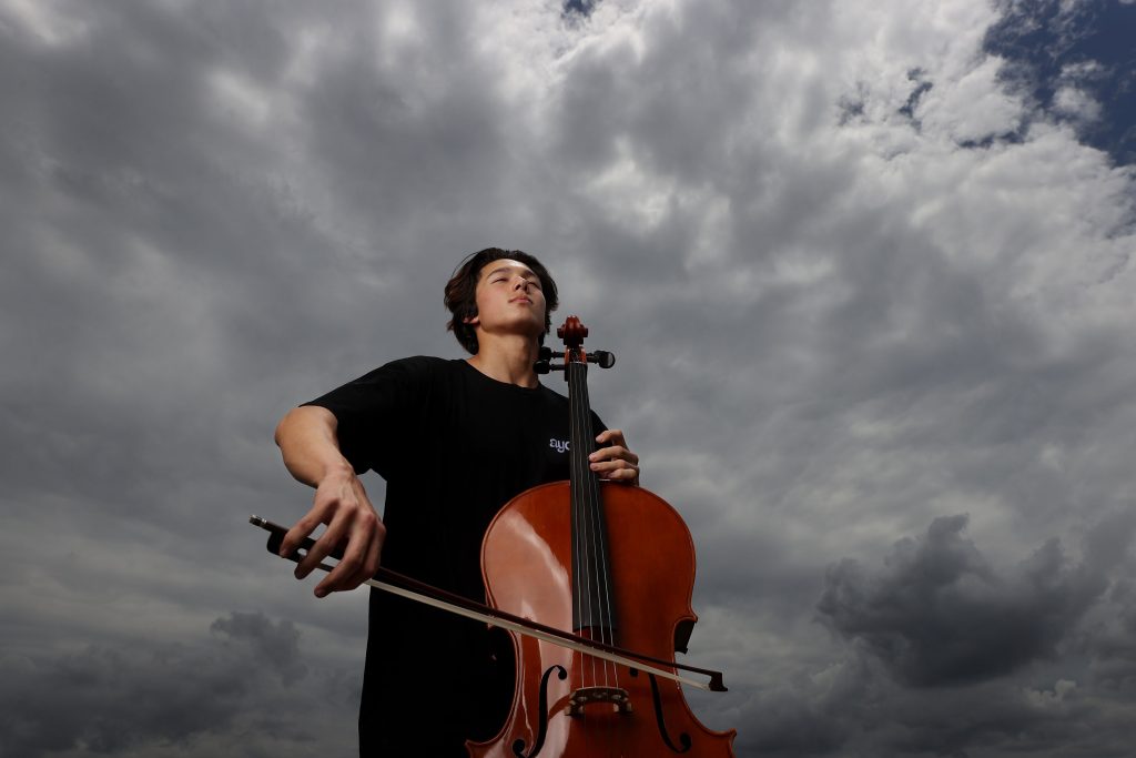 Cellist in front of a stormy background