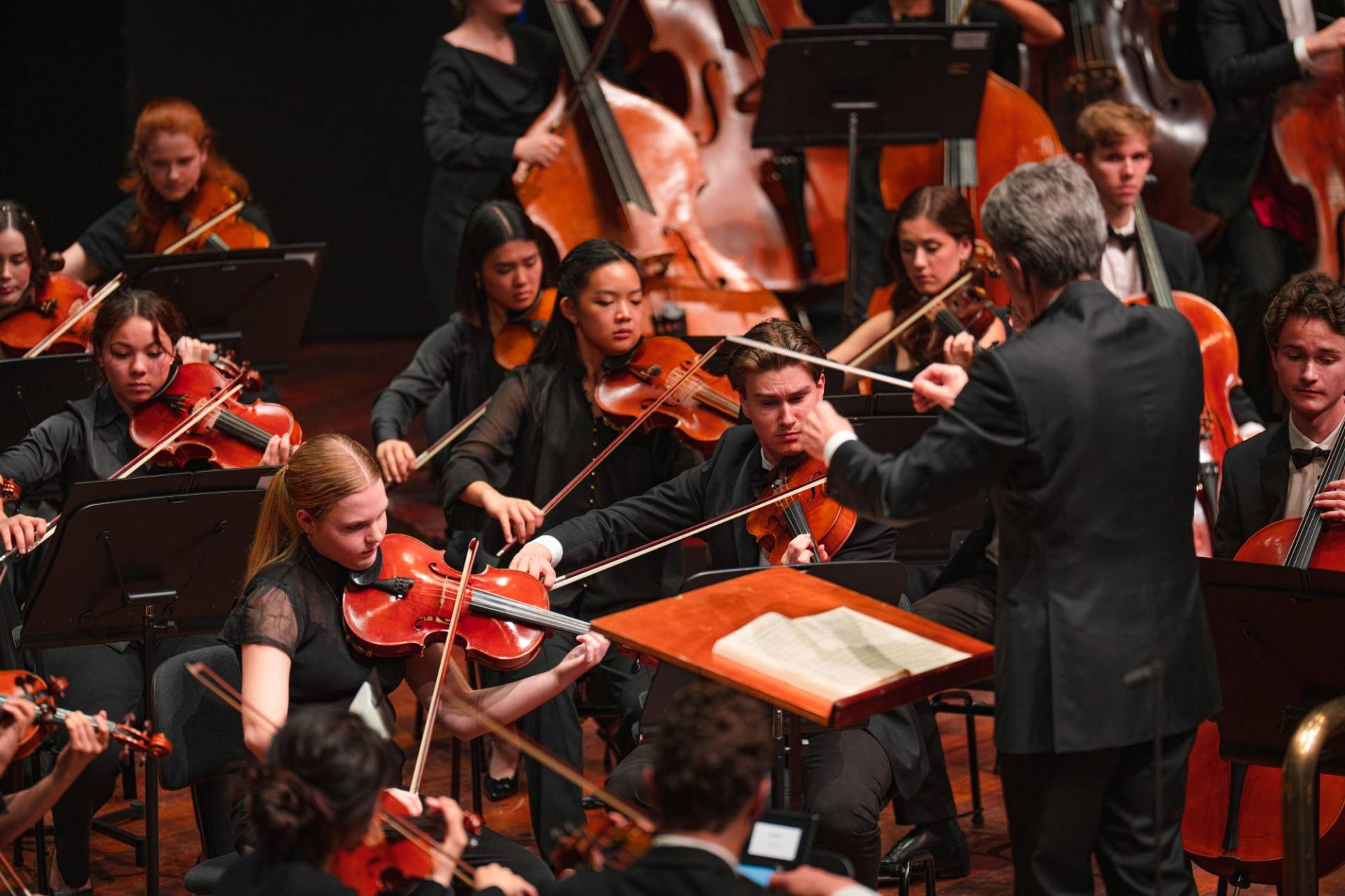 String musicians of the Australian Youth Orchestra conducted by Eivind Aadland at the Perth Concert Hall. They are wearing concert blacks. Edify Media 2023